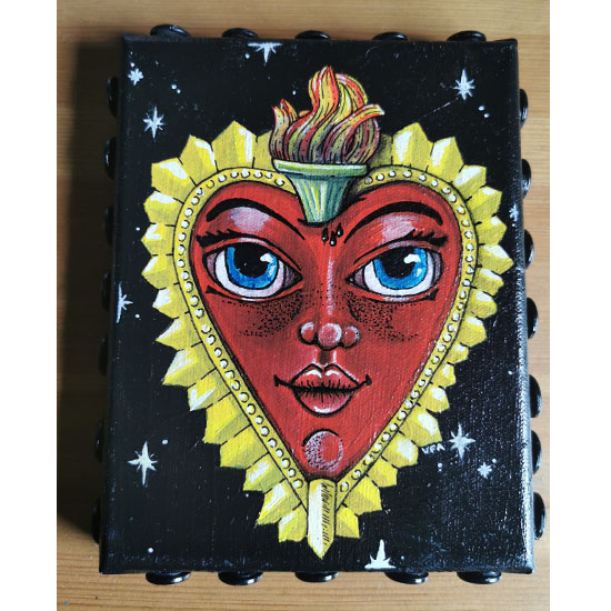 Illustration d’un cœur sacré rose avec un visage expressif, yeux ronds, joues volumineuses, orné de pics dorés et d’une flamme, sur fond noir.